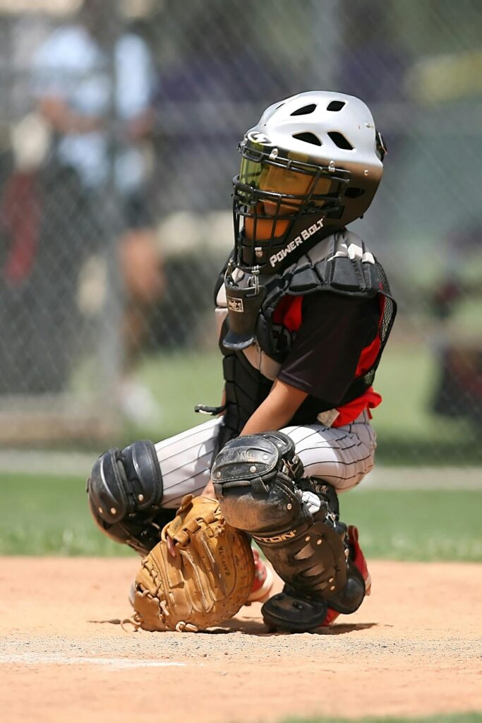 A young baseball catcher in full gear crouches on the field, ready for action.